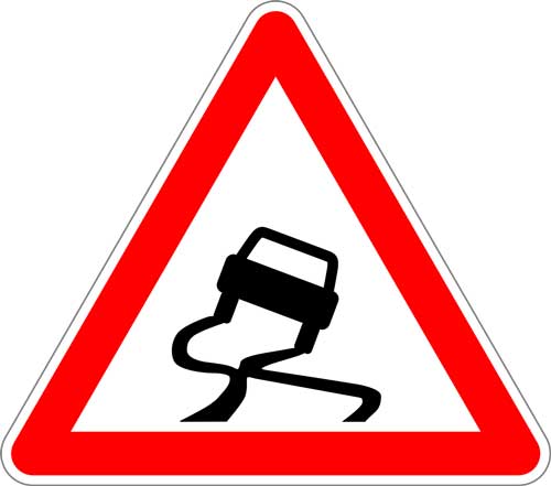 Winter road warning sign beside a snowy road