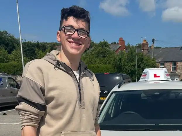 Newly passed driver standing by Paul Singletons driving school car
