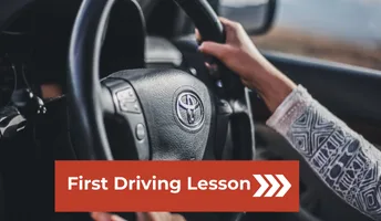 Learner driver holding the steering wheel during a first driving lesson