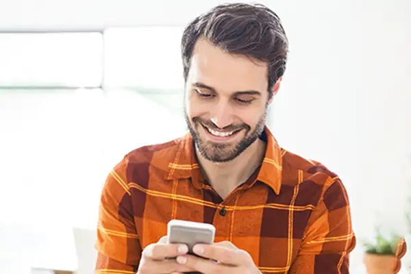 Man applying for driving lesson finance using his mobile phone