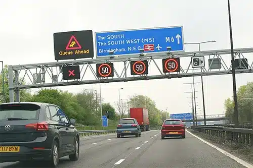 Smart motorway overhead signs showing speed limits and lane-control signals