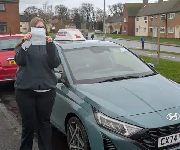 Charliegh hiding behind her driving test pass certificate in Abergele