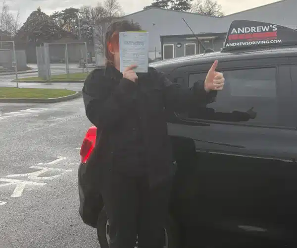 Jess in Bangor Driving Test Centre hiding behind her pass certificate