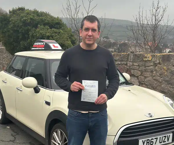 "John in Old Colwyn overlooking the bay with Jimmy'tic mini and displaying his new driving test pass"