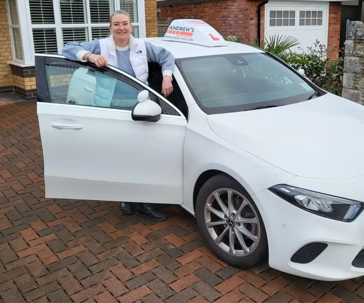 Julie Sheard with her car after qualifying as an approved driving instructor