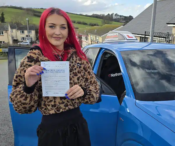 Kaya in Colwyn Bay standing next to Ryans car holding her driving test pass