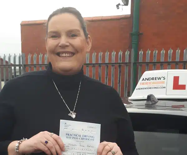 New driver smiling and holding her pass certificate in The Rhyl Driving Test Centre