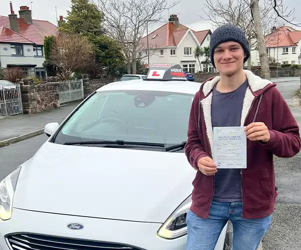 A new driver in Deganwy, standing next to Dewis driving instructor car