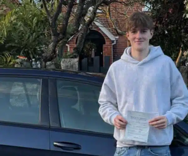 Happy learner in Denbigh with pass certificate