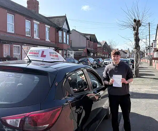"Chloe in Rhyl standing with her driving test pass certificate next to Marcus's tuition car"