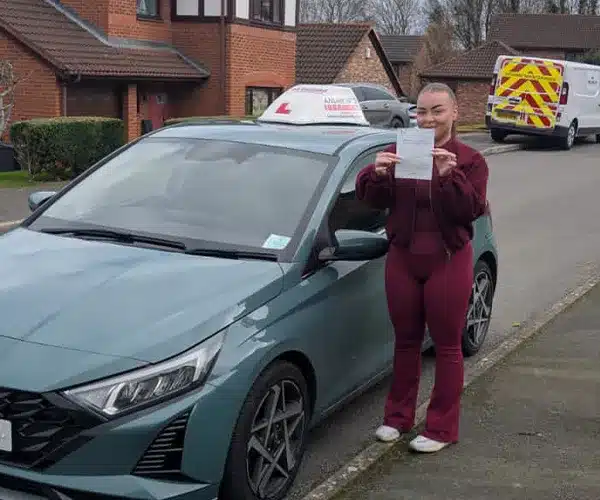 "Morgan in Abergele with her new pass certificate, standing next to Jack's driving tuition car"