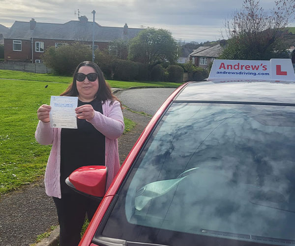 Naz stands on a residential street holding her drignage after passing her automatic test in Bangor.