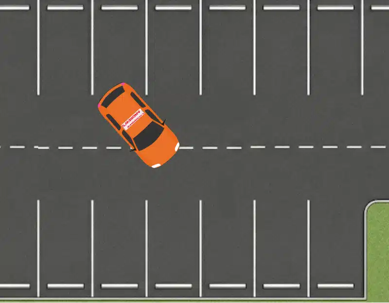 Orange learner car angled while reversing into a parking bay
