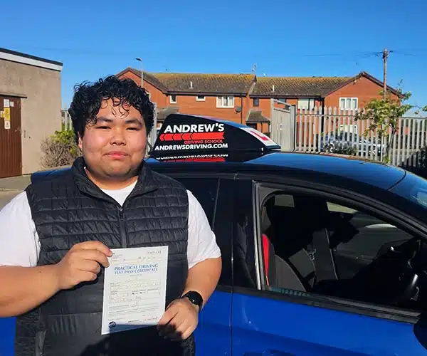 John holding his driving test pass certificate aftl Driving Test Centre with instructor John Hewitt