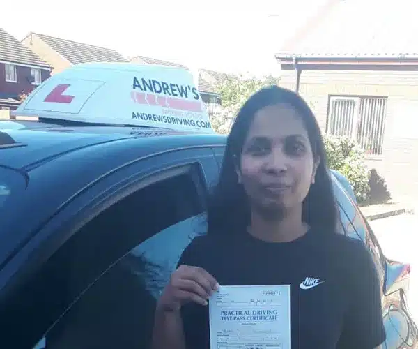 Ruby holding her driving test pass certificate at yl Driving Test Centre with Barry’s automatic car