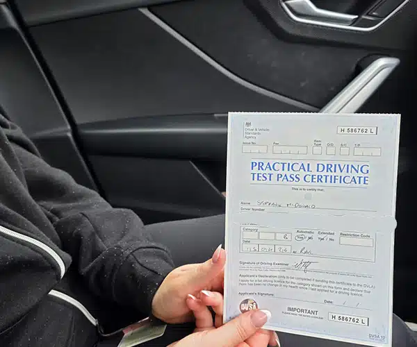 Steph holding her practical driving test pass certiving Test Centre after passing her driving test.