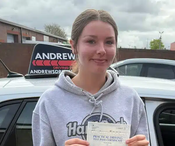 Tillie holding practical driving test pass certificate at Rhyl Driving Test Centre