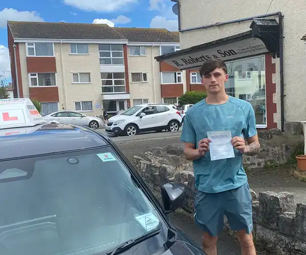 Alex Day from Abergele celebrates passing his driving test first time in Rhyl with instructor Andy Kirkham from Andrew's Driving School.