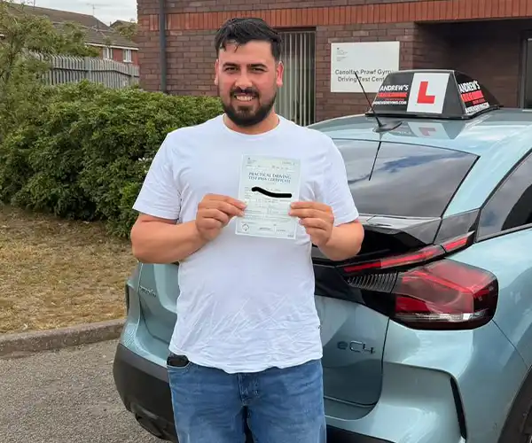 Ahmad celebrates passing his driving test in Rhyl with zero minors after lessons with Abdullah from Andrew's Driving School.
