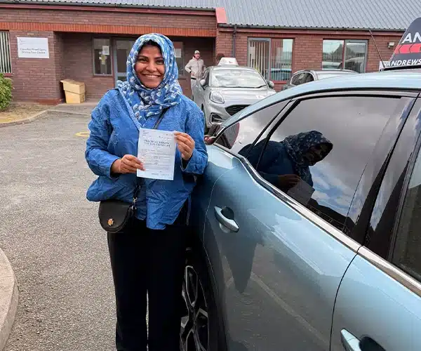 Hafiza from Rhyl celebrates passing her automatic driving test in Rhyl with instructor Abdullah from Andrew's Driving School.