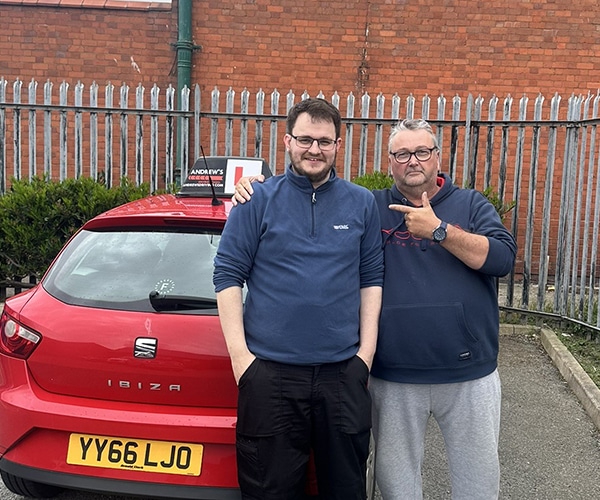 John Alderton celebrates passing his ADI Part 3 test with Paul Singleton from Andrew's Driving School.