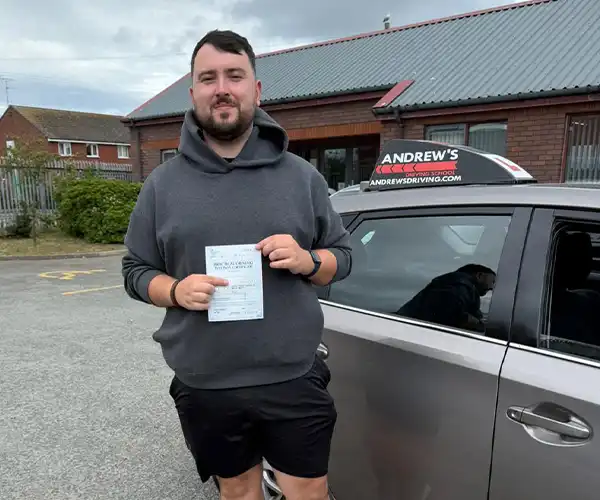 Josh Edwards from Colwyn Bay celebrates passing his driving test first time in Rhyl with instructor Ursula from Andrew's Driving School.