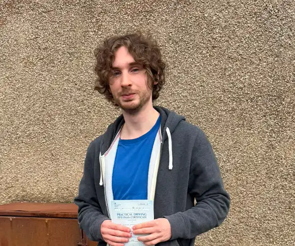 Nicholas celebrates passing his driving test first time in Rhyl with instructor Ursula from Andrew's Driving School.