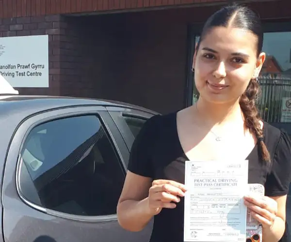 Ratha celebrates passing an automatic driving test in Bangor with instructor Barry Evans from Andrew's Driving School.