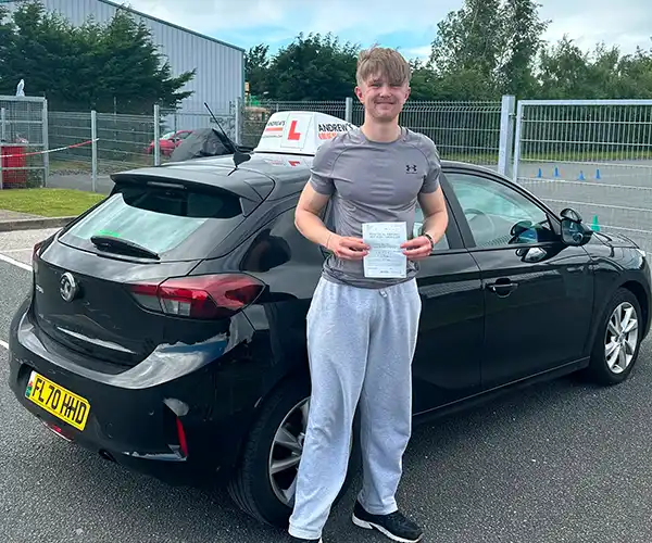 Richard Bell celebrates passing his driving test in Bangor with zero minors and instructor Geraint from Andrew's Driving School.