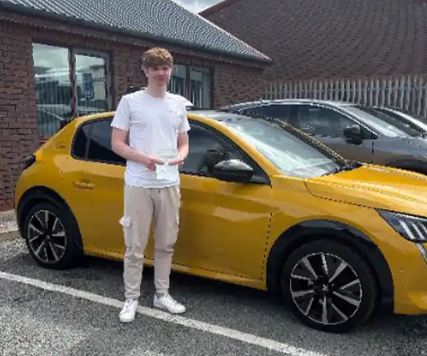 Rylie celebrates passing a driving test at Rhyl Driving Test Centre with instructor Paul Craft from Andrew's Driving School.