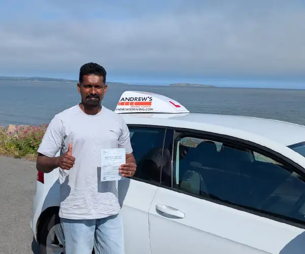 Supas celebrates passing a driving test first time in Bangor with instructor Tomas from Andrew's Driving School.