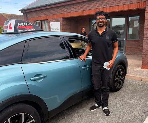 Dr Nithin celebrates passing his automatic driving test first time in Rhyl with instructor Abdullah from Andrew's Driving School.