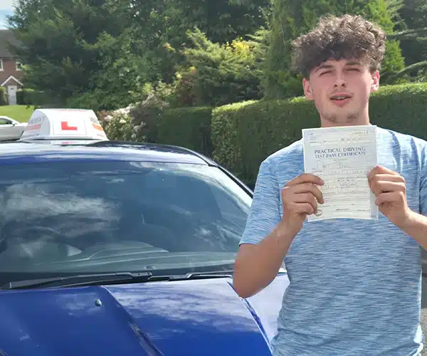 Dyfed standing by Craig's car in Wrexham with his pass certificate