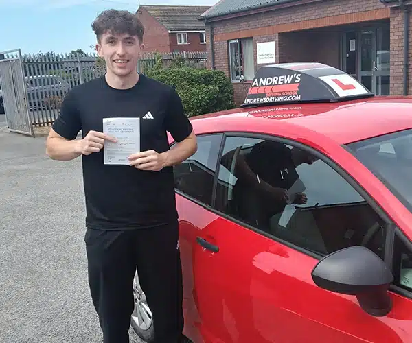 Max Syson celebrates passing his driving test first time in Rhyl with instructor John Alderton from Andrew's Driving School.